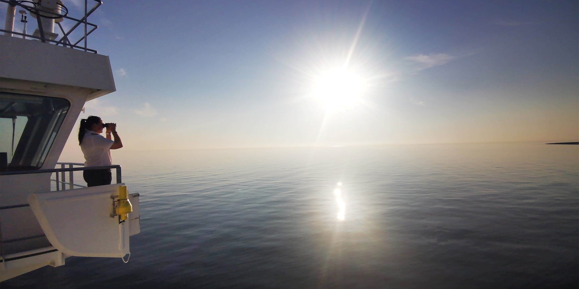 Die Kapitänin Maryann Bendiksen schaut auf einen wunderschönen, blauen Sonnenuntergang