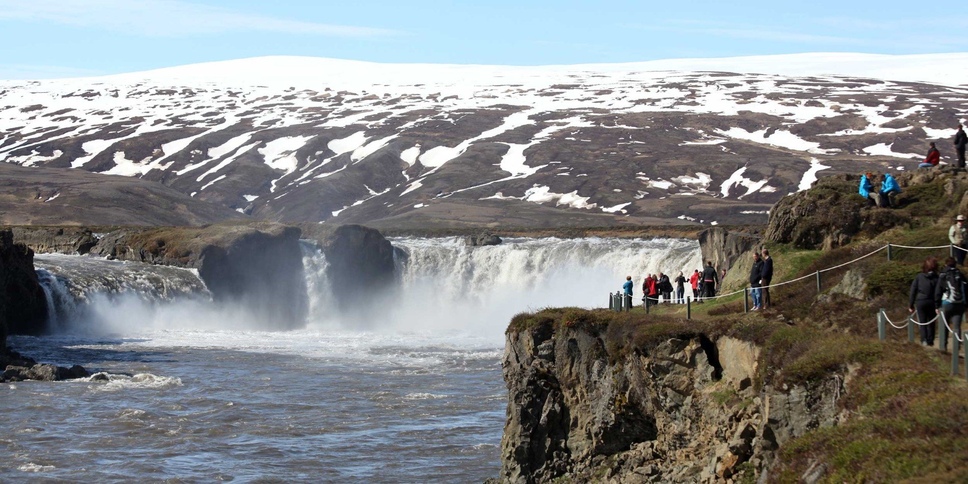 Eine Gruppe von Menschen, die neben einem Wasserfall stehen
