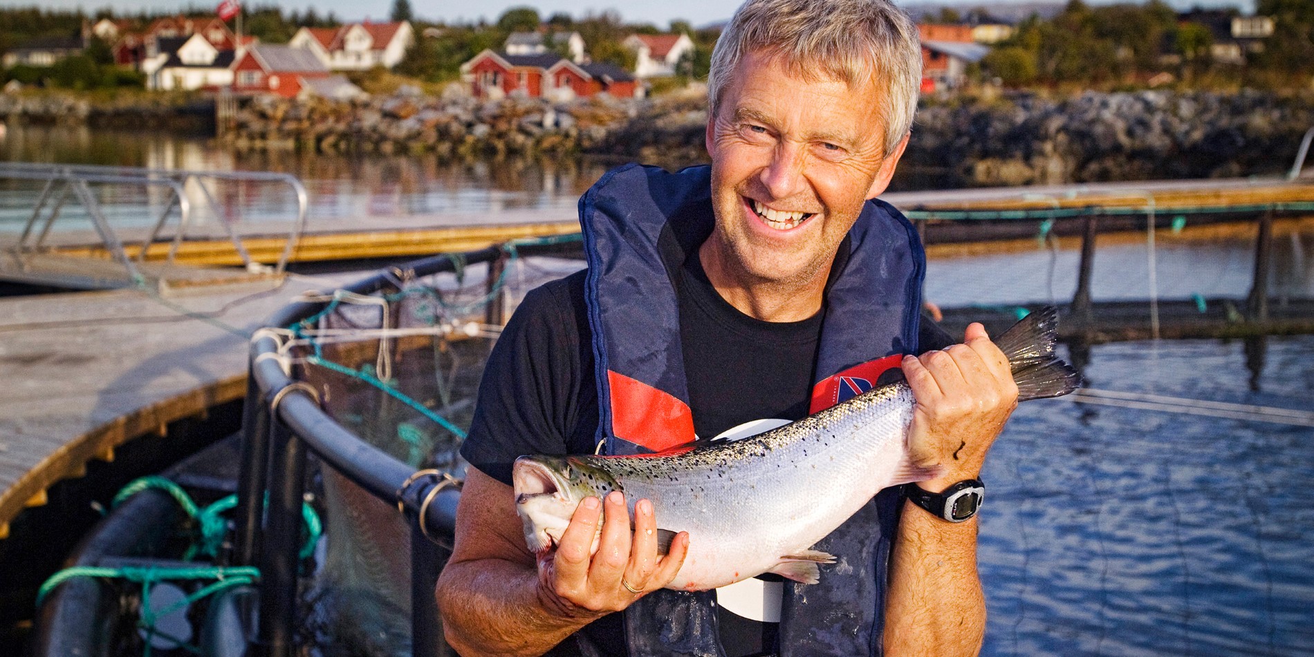 Person holding a salmon at the Brønnøysund salmon farm