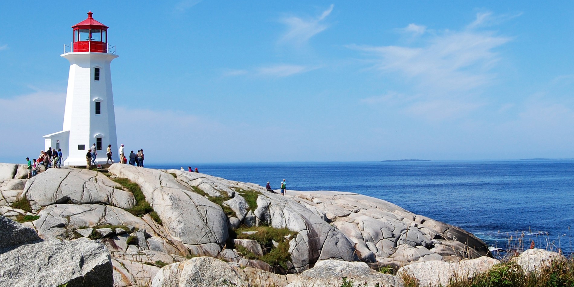 Eine Statue einer Person, die auf einem Felsen in der Nähe des Ozeans sitzt